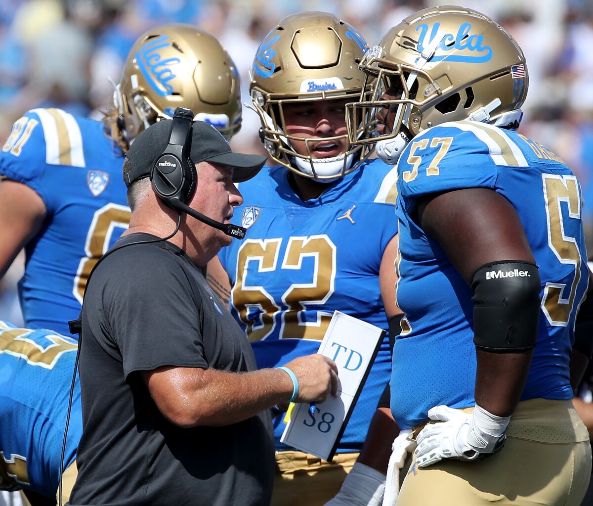 UCLA head coach Chip Kelly talks with his players during a break.