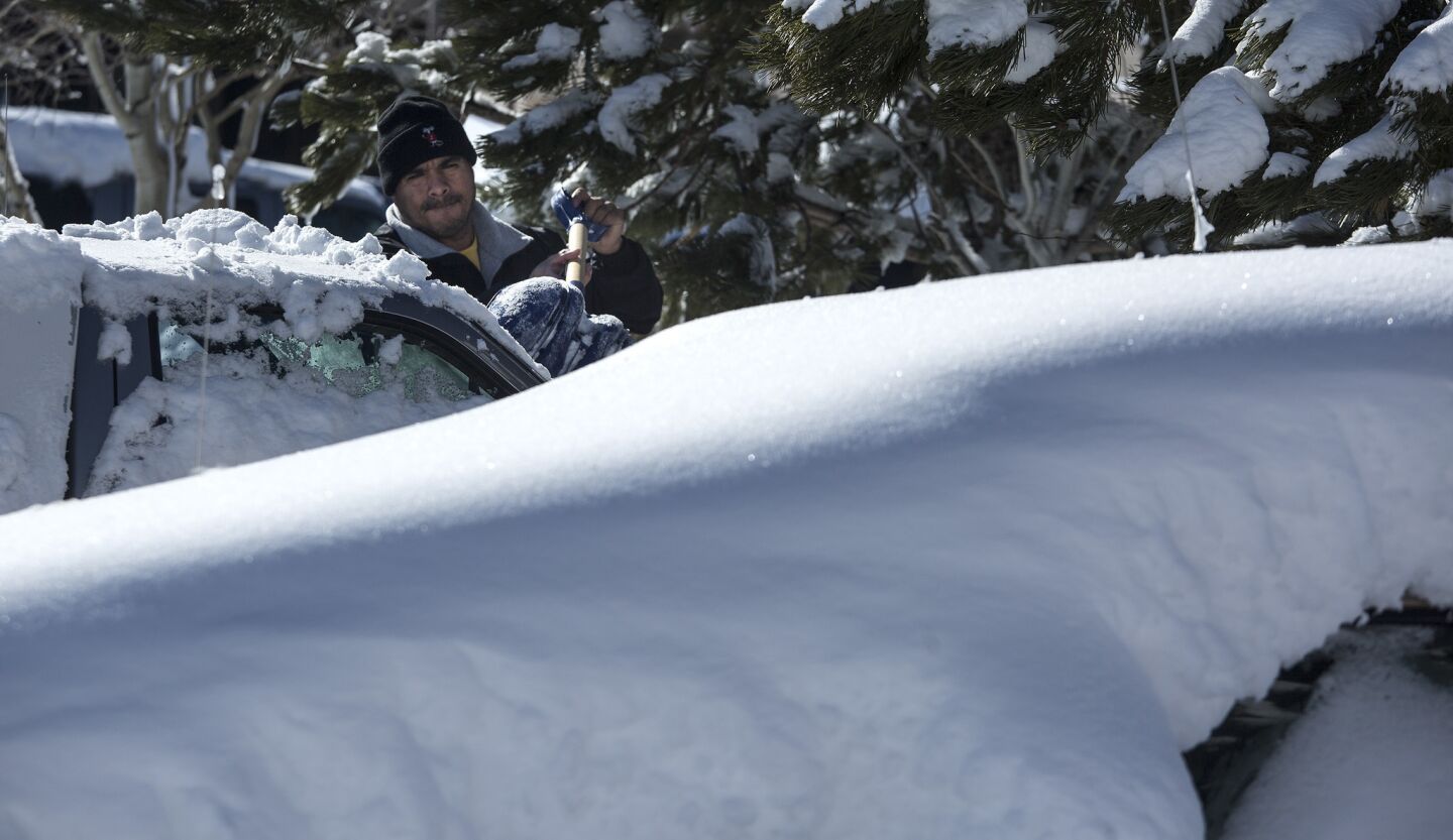 Jorge Gaydam digs out his truck in a parking lot.