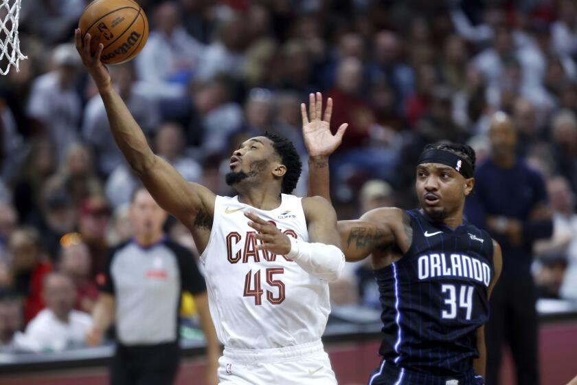 Donovan Mitchell (45), de los Cavaliers de Cleveland, ataca la canasta ante la mirada de Wendell Carter Jr. (34), del Magic de Orlando, durante la primera mitad del Juego 2 de la serie de primera ronda de playoffs de baloncesto de la NBA, el lunes 22 de abril de 2024, en Cleveland. (AP Foto/Ron Schwane)