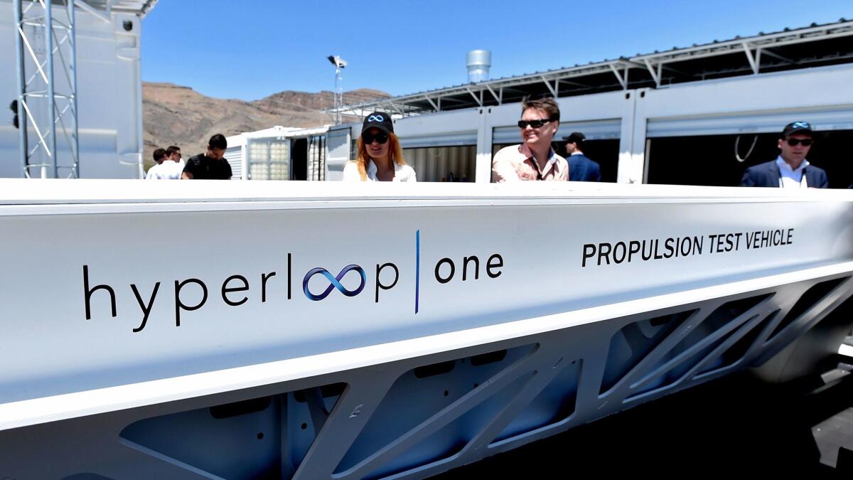 People look at a demonstration test sled at a Hyperloop One site in 2016 in North Las Vegas, Nev.