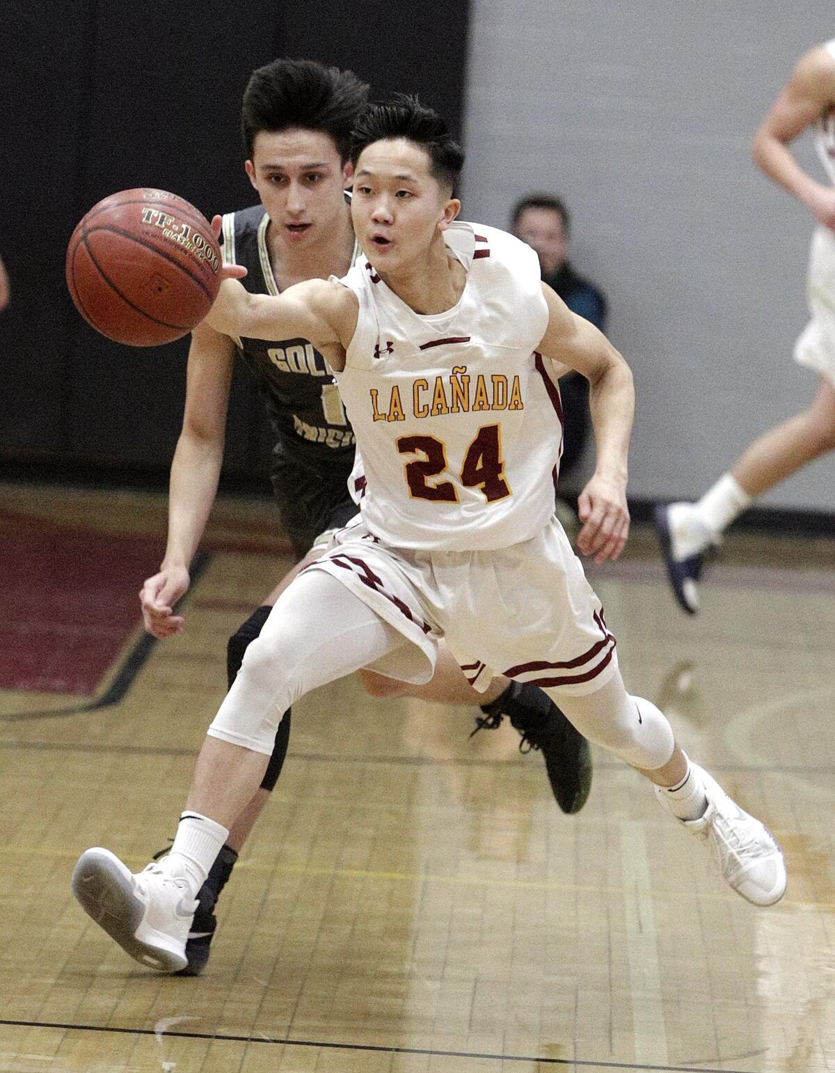 La Canada's Darren Pung recovers the ball after it was knocked away from him by St. Francis' Frederick Harper in CIF Southern Section Division II-A first-round boys' basketball playoff at La Canada High School on Wednesday, February 12, 2020.