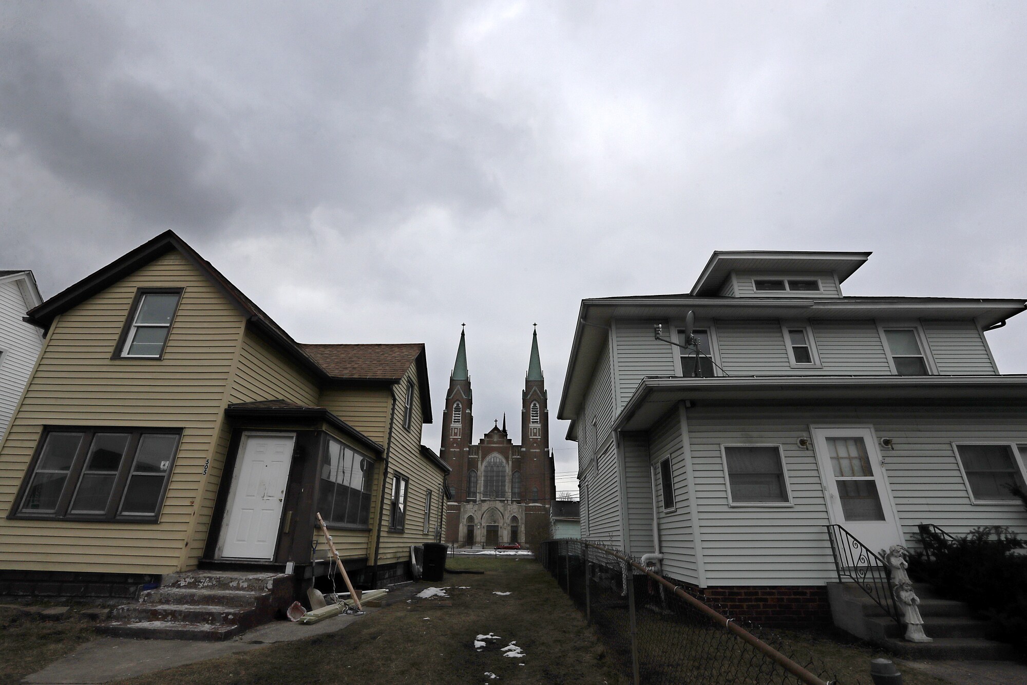 A pair of old homes frame St. Adalbert Catholic Church in the west side of South Bend, Ind.