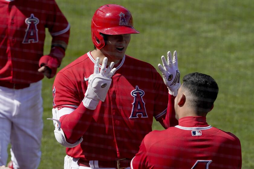 Los Angeles Angels' Shohei Ohtani motions to Jose Iglesias (4) after hitting a two run home run against the Cleveland Indians during the third inning of a spring training baseball game, Tuesday, March 16, 2021, in Tempe, Ariz. (AP Photo/Matt York)