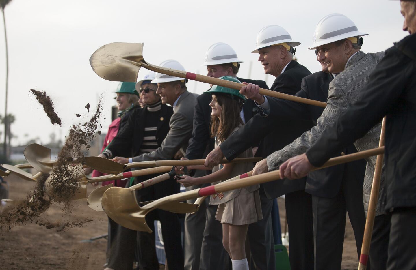 Girl Scout Olivia Bobrownicki with troop 356 out of Irvine, flanked by members of the Newport Beach City Council including Mayor Rush Hill toss a shovel full of dirt during the groundbreaking ceremony for Marina Park on Balboa Peninsula on Tuesday, February 11. (Scott Smeltzer, Daily Pilot)