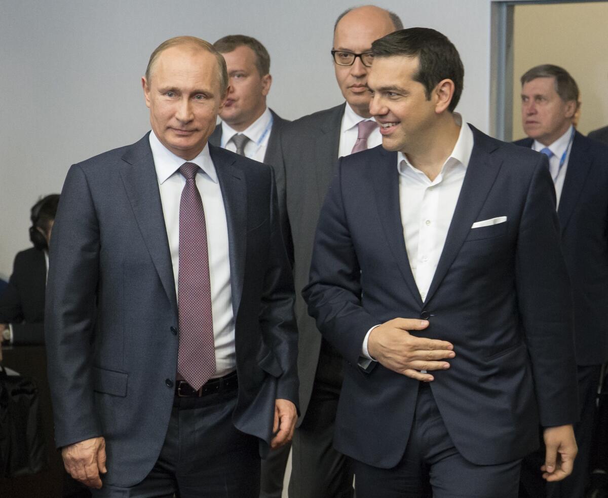Russian President Vladimir Putin, left, and Greek Prime Minister Alexis Tsipras arrive for their talks Friday at the St. Petersburg International Economic Forum in the Russian city.