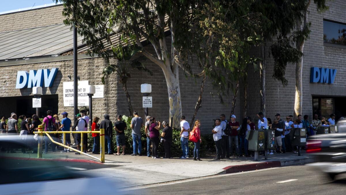 Customers wait in a line that stretches around the building and down the block at a California Department of Motor Vehicles Office in South Los Angeles on Aug. 7.