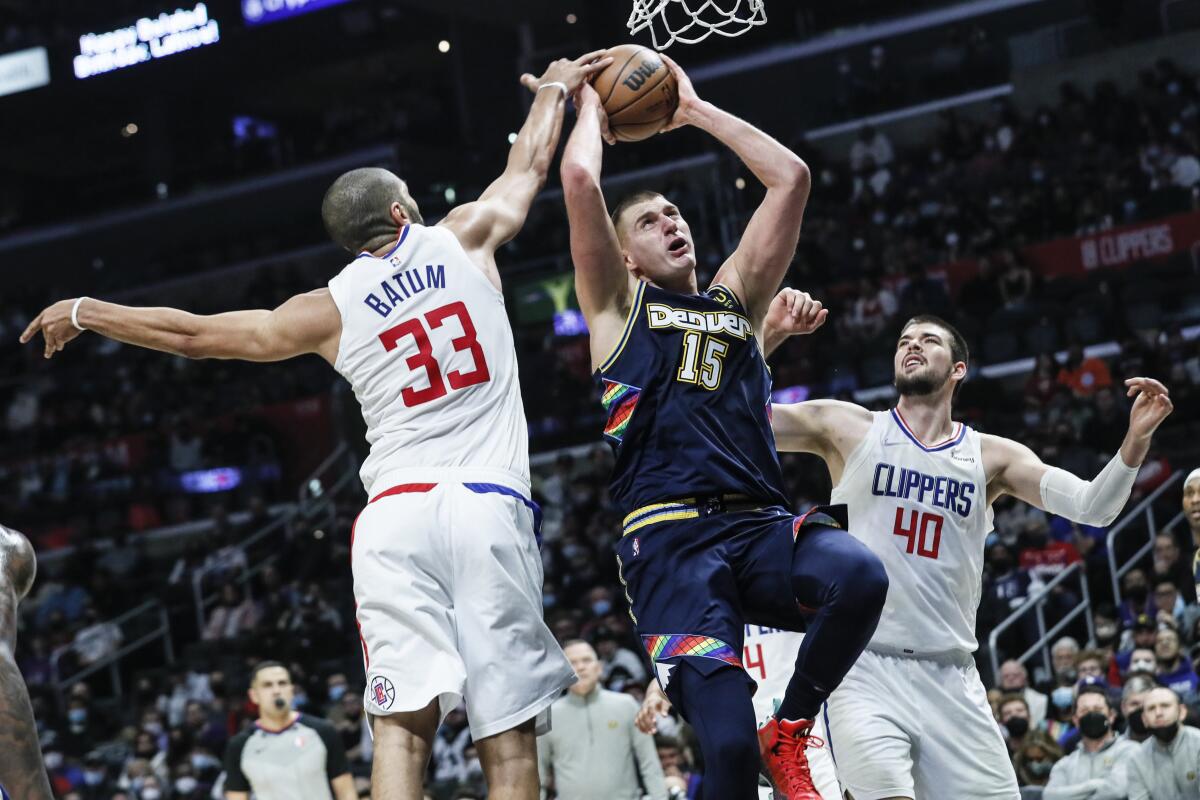 Denver Nuggets center Nikola Jokic drives to the basket between Clippers forward Nicolas Batum and center Ivica Zubac.