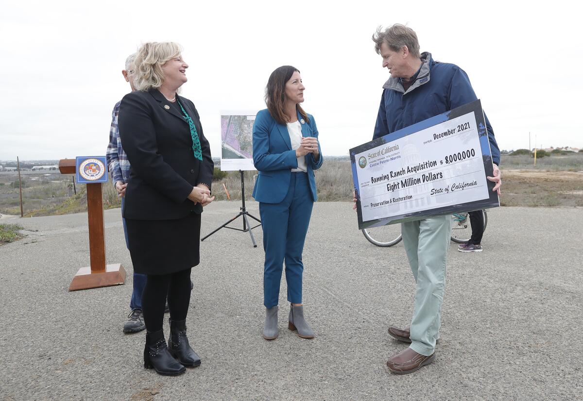 Terry Welsh, president of Banning Ranch Conservancy, holds the ceremonial check.