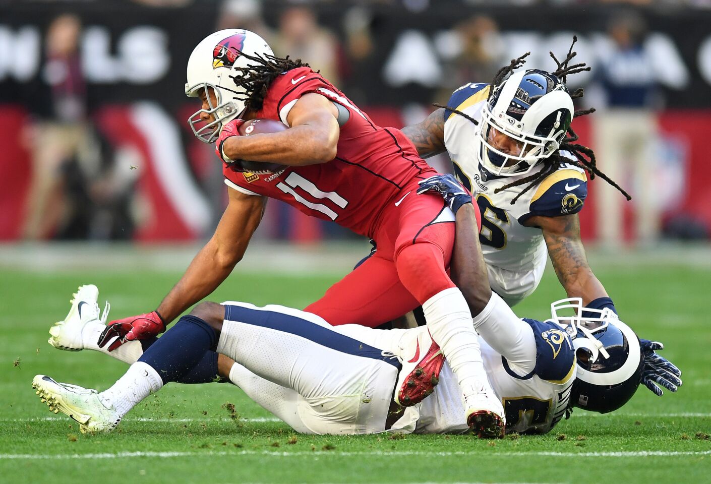 Arizona Cardnials receiver Larry Fitzgerald is brought down by Rams' Cory Littleton and Mark Barron (26) in the first quarter at State Farm Stadium on Sunday.