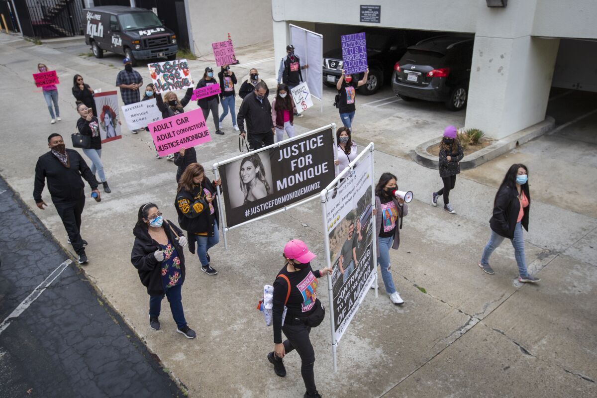 Protesters carrying signs that say "Justice for Monique" and other slogans