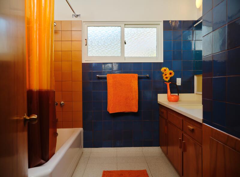 Blue and orange tiles cover the bathroom walls.