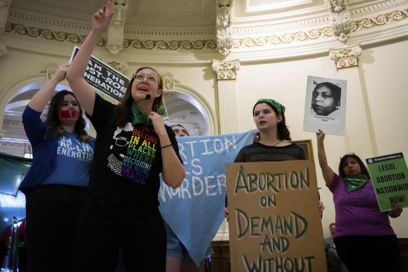 Sarah Bentley, second from left, leads songs at an International Women's Day Sit-In for Abortion Rights in the Texas State Capitol Rotunda, Wednesday, March 8, 2023, in Austin, Texas. Both abortion rights and anti-abortion protesters were present on the rotunda, speaking to curious passers-by, singing songs and occasionally chanting. (Sara Diggins/Austin American-Statesman via AP)