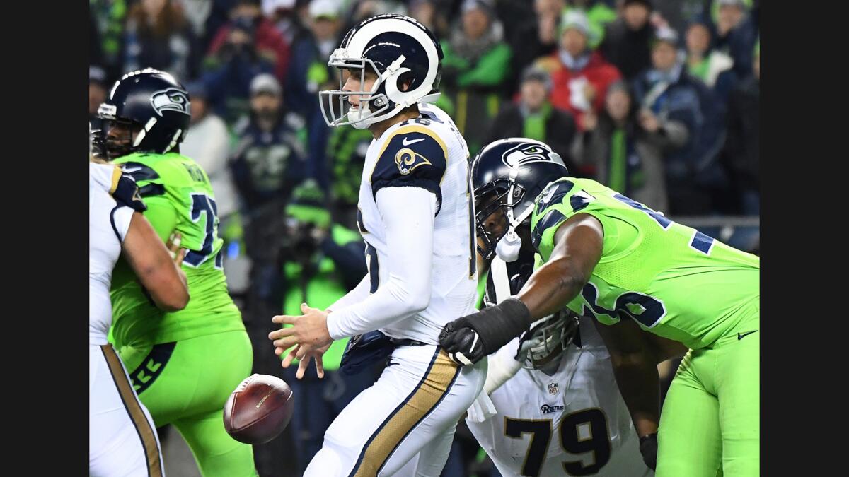 Rams quarterback Jared Goff loses the ball as he's hit by Seahawks defensive end Cliff Avril in the third quarter at CenturyLink Field in Seattle on Thursday.