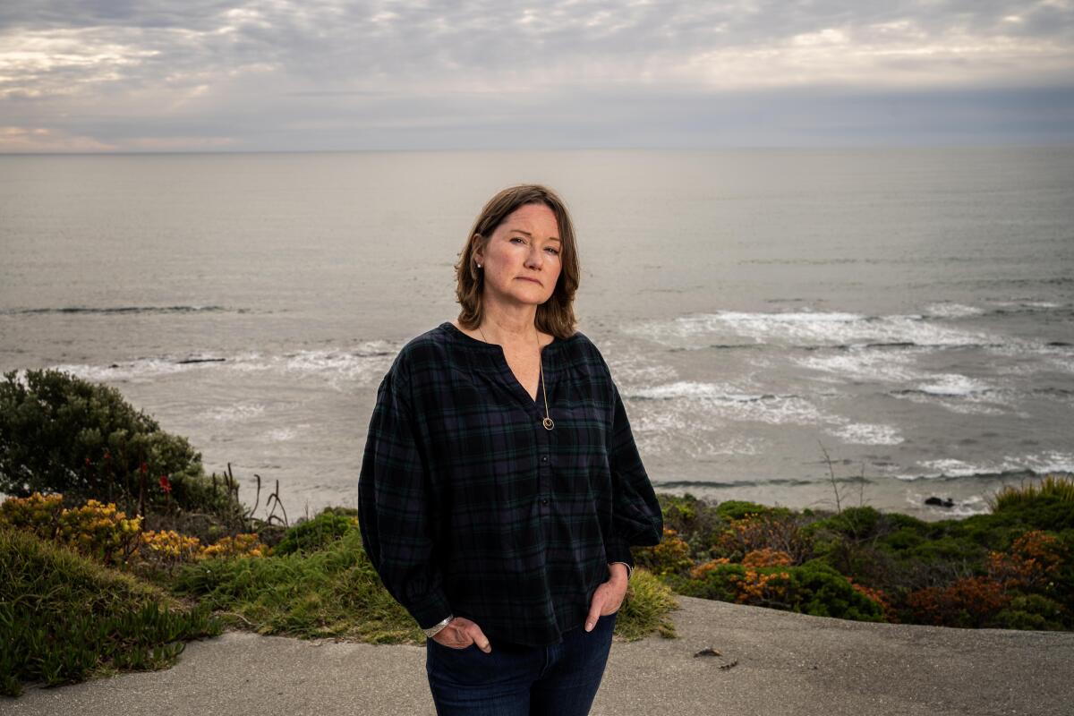 Sabrina Brennan stands on a bluff overlooking the sea. 