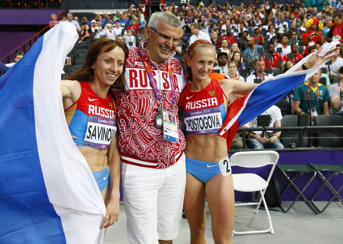 Russian athletes Mariya Savinova and Ekaterina Poistogova celebrate with Coach Vladimir Kazarin after the women's 800m final at the 2012 Olympic Games. Both athletes are among five Russian runners targeted for a lifetime ban.