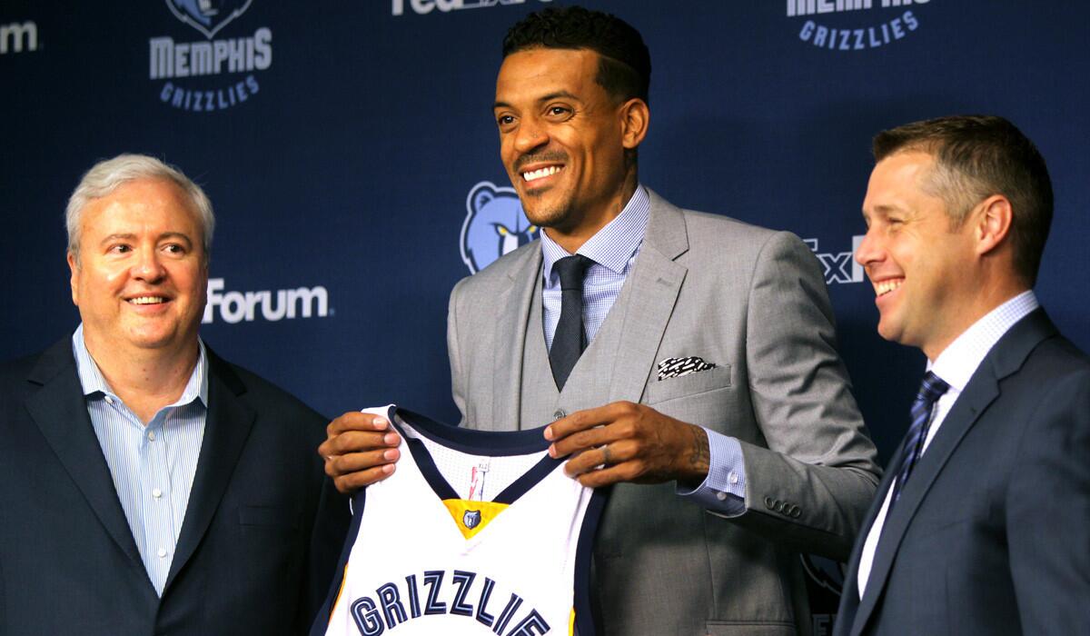 Memphis Grizzlies Matt Barnes holds his jersey, flanked by general manager Chris Wallace, left, and head coach Dave Joerger, right, during his introductory press conference on Tuesday.