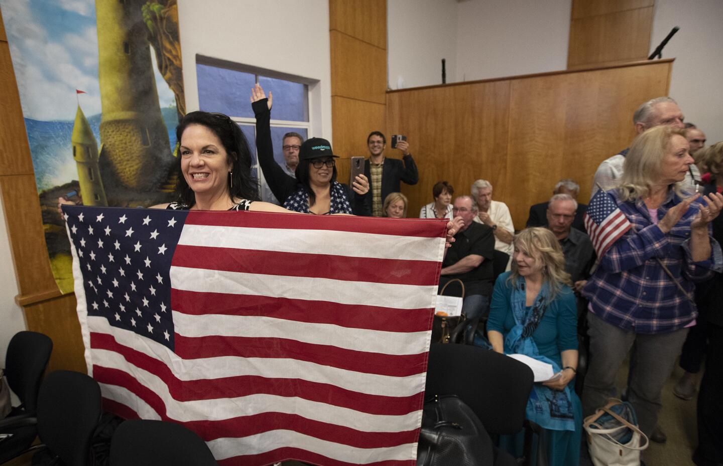 Lisa Collins holds an American flag during a Laguna Beach City Council meeting Tuesday in which the council considered the flag design on city police cars.