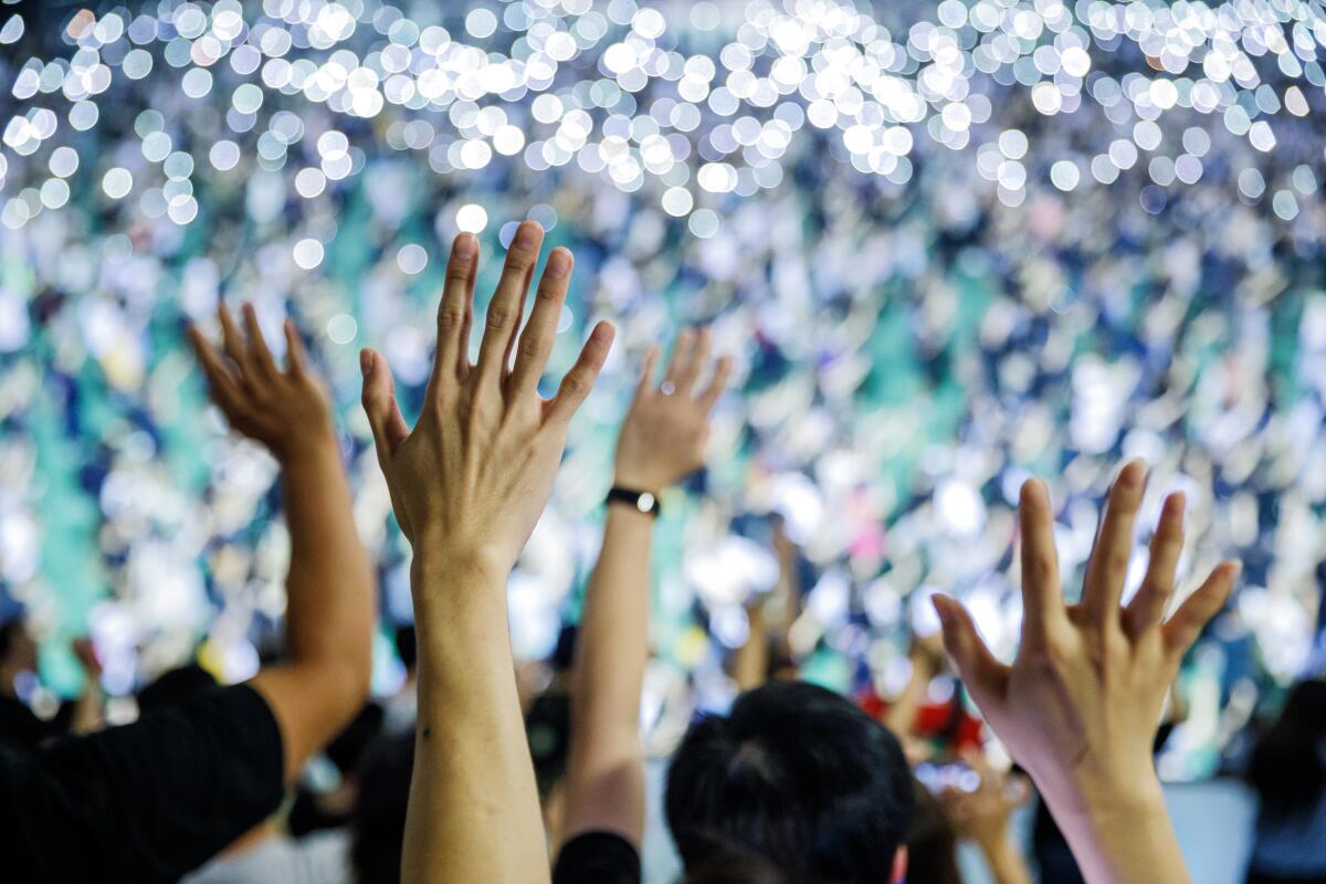 Pro-democracy demonstrators raise their hands to signify the five demands, as they rally in Tsuen Wan in response to the aftermath of the police's use of live ammunition during clashes with demonstrators.