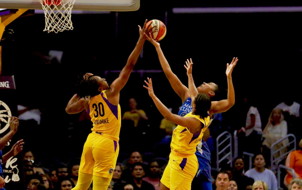 Sparks forward Nneka Ogwumike (left) blocks a shot by Minnesota’s Damiris Dantas during the first half of Tuesday's game.