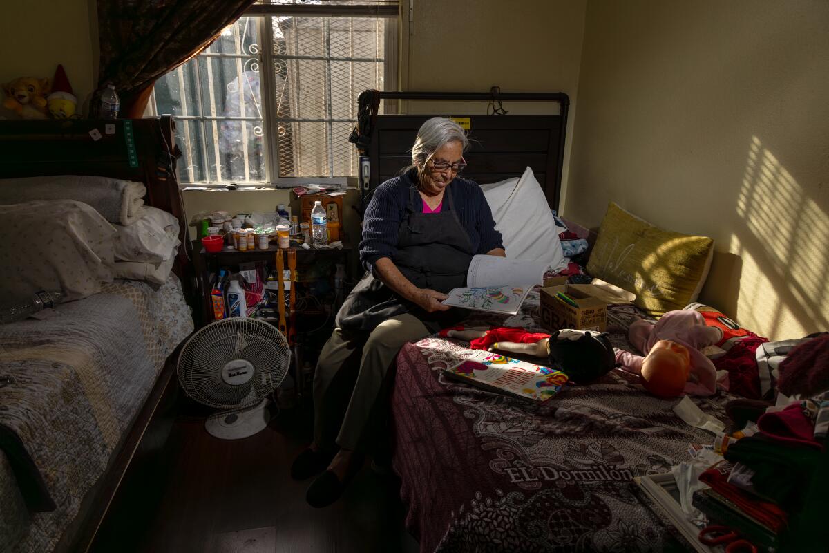Blanca Ruiz, 75, reads through paperwork sent by the city regarding the demolition of her apartment in South Los Angeles.