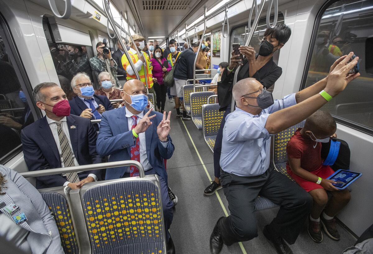 A man takes a selfie inside a train with other people