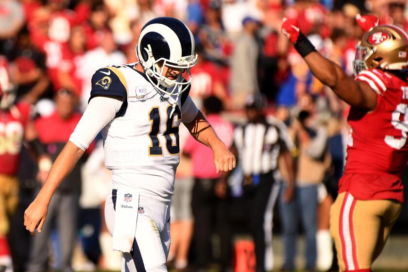 LOS ANGELES, CALIFORNIA OCTOBER 13, 2019-Rams Jared Goff walks off the field as 49ers Solomon Thomas celebrates after a missed 4th down play late in the 4th qaurter at the Coliseum Sunday. (Wally Skalij/Los Angeles Times)
