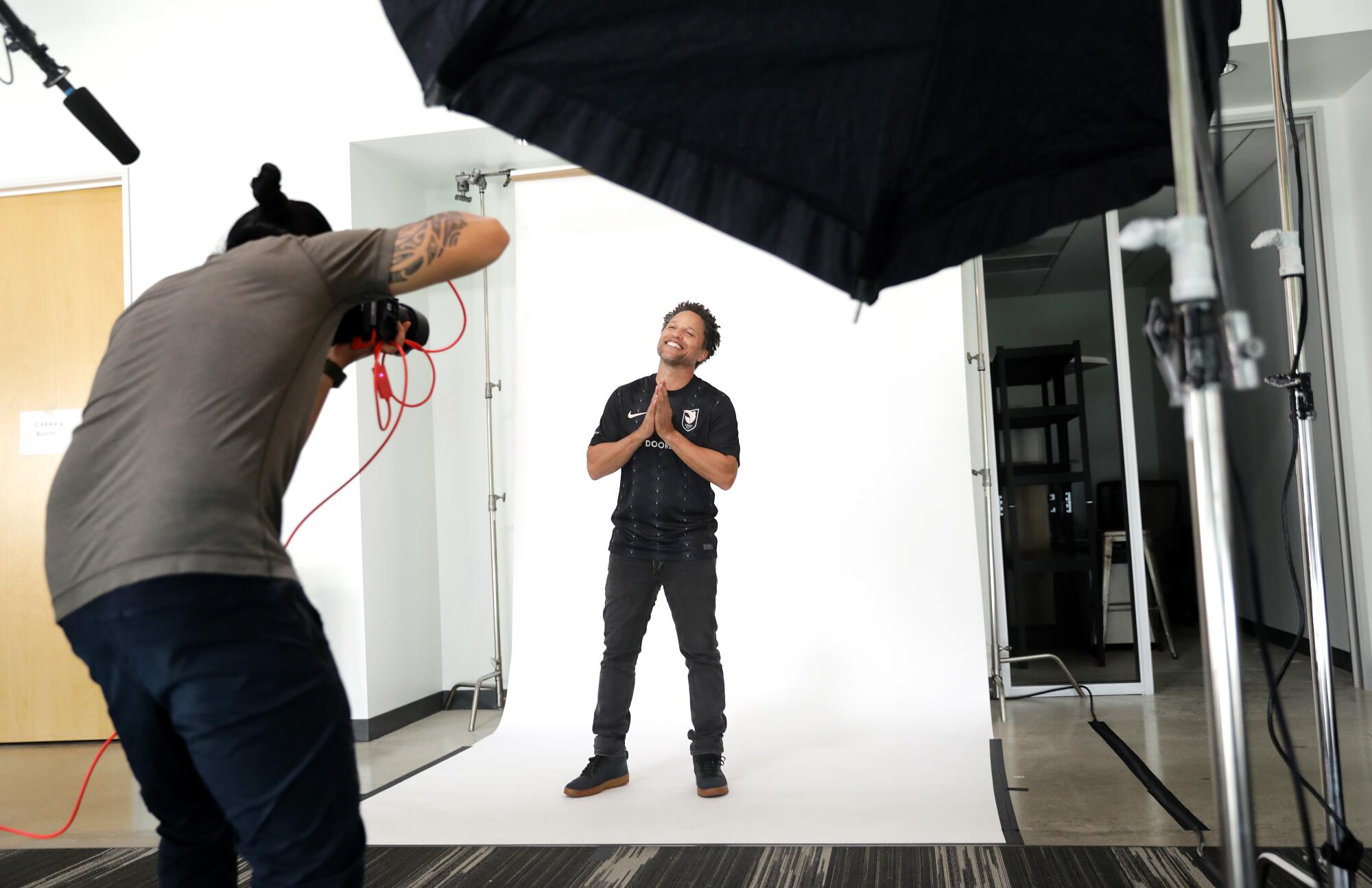 Angel City FC investor Cobi Jones wears the team's inaugural home jersey during a photo shoot.