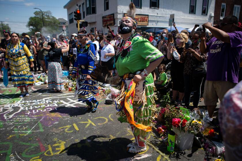 MINNEAPOLIS , MINNESOTA - JUNE 01: Local Indians pay their respects at the makeshift memorial for George Floyd at intersection in front Cup Foods where Floyd was murdered by a Minneapolis police officer on Monday, June 1, 2020 in Minneapolis , Minnesota. (Jason Armond / Los Angeles Times)