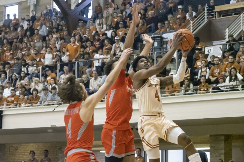 Texas guard Tyrese Hunter (4) goes up to shoot against Texas Rio Grande Valley guard Will Johnston (4) and forward Ahren Freeman (11) during the first half of an NCAA college basketball game Saturday, Nov. 26, 2022, in Austin, Texas. (AP Photo/Michael Thomas)