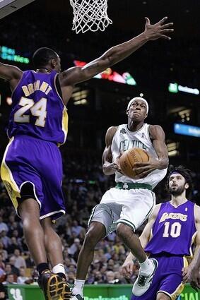 Celtics guard Rajon Rondo tries to shoot over Kobe Bryant.