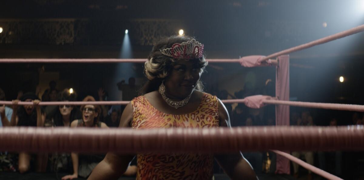 A woman wrestler in a leopard-print suit and gaudy crown.