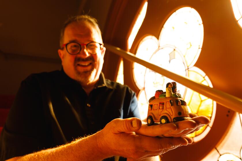 Pastor David Bahr poses with a Volkswagen bus-themed Nativity scene from Central America at Mission Hills United Church of Christ on Thursday, Dec. 21, 2023.