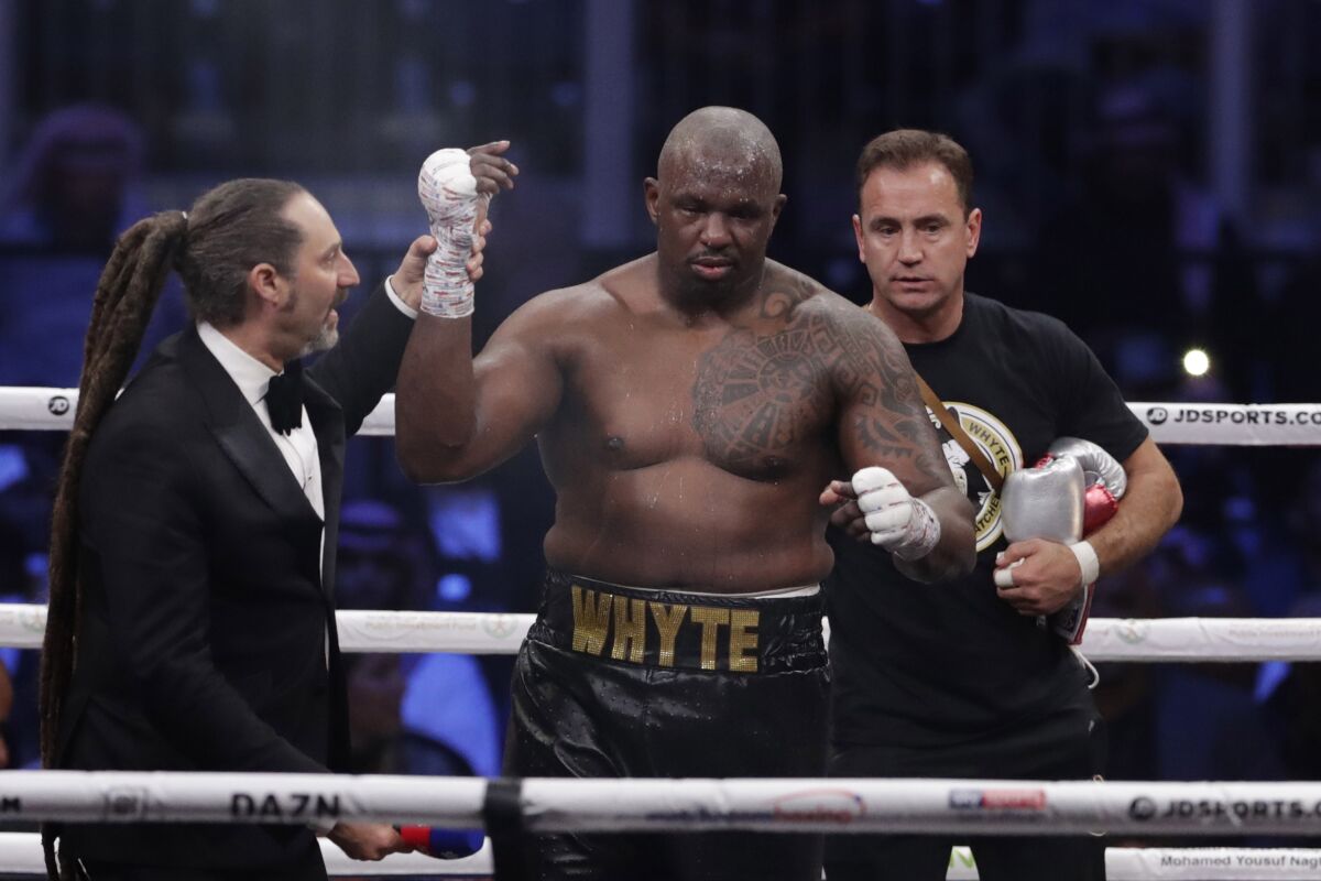 FILE - Dillian Whyte of Britain celebrates winning against Mariusz Wach of Poland fight during a heavyweight undercard boxing match at the Diriyah Arena, in Riyadh, Saudi Arabia, Saturday, Dec. 7, 2019. Whyte’s journey to a long-awaited shot at the world heavyweight title has followed a well-worn path for boxers, from a grim existence on the streets to the salvation of the ring. (AP Photo/Hassan Ammar, File)