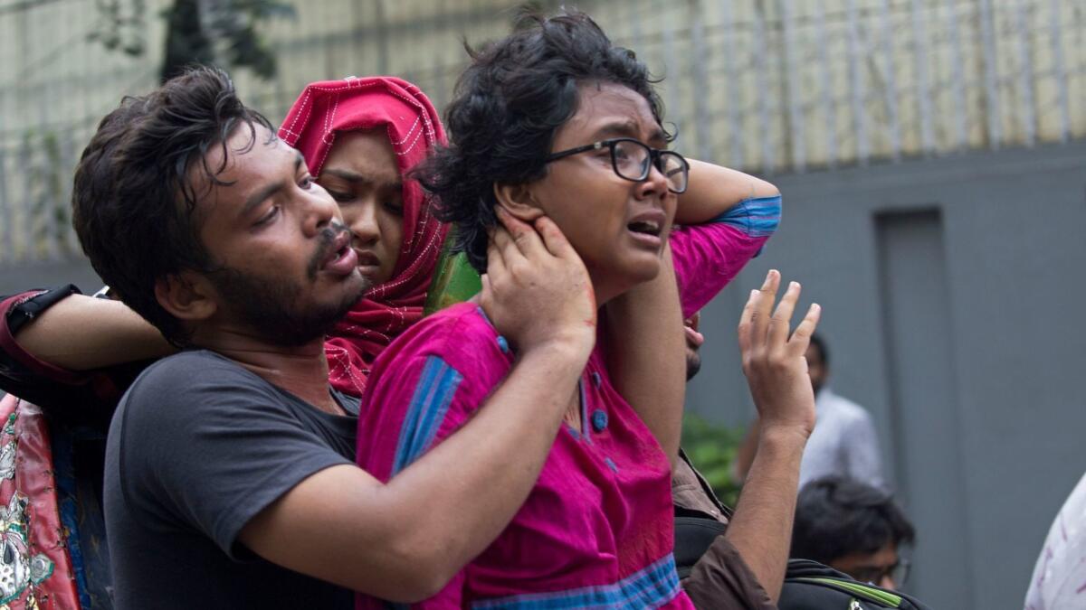 People assist an injured student as Dhaka University students protest to demand safer roads in Bangladesh on Aug. 5, 2018.