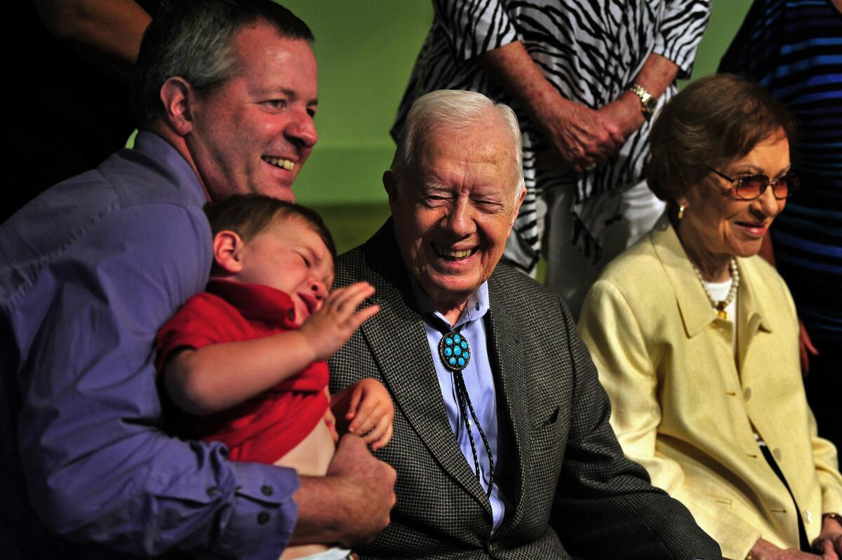 President Carter, with wife Rosalynn in 2015, was a good sport when 2-year-old Lennon Case-Simonson, with father Andy Case-Simonson, wasn't in the mood for a photo with him.