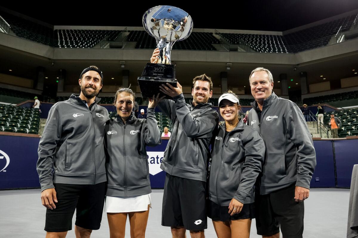 Members of the Orange County Breakers celebrate with the King Trophy after winning the World Team Tennis title on Sunday.