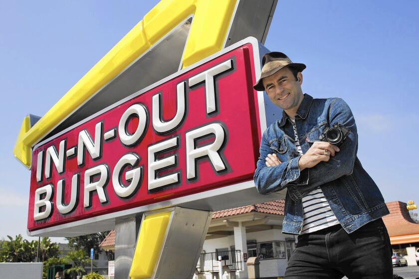 Photographer Patrick Fraser stands in front of an In-N-Out Burger in Westminster. Fraser photographed 12 In-N-Out Burger restaurants throughout Orange County as part of the “Smile: Expressions of Orange County” photography exhibit at the Orange County Great Park Gallery.