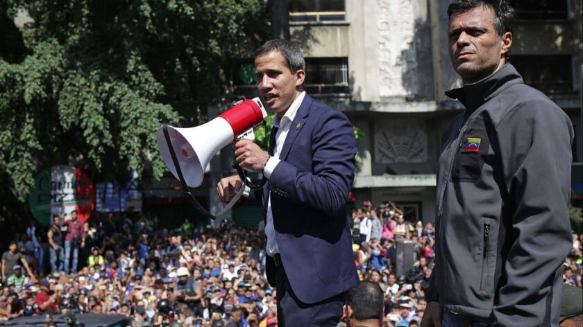 Venezuelan opposition leader and self-proclaimed interim President Juan Guaido, left, speaks to supporters next to opposition politician Leopoldo Lopez in Caracas on April 30, 2019.