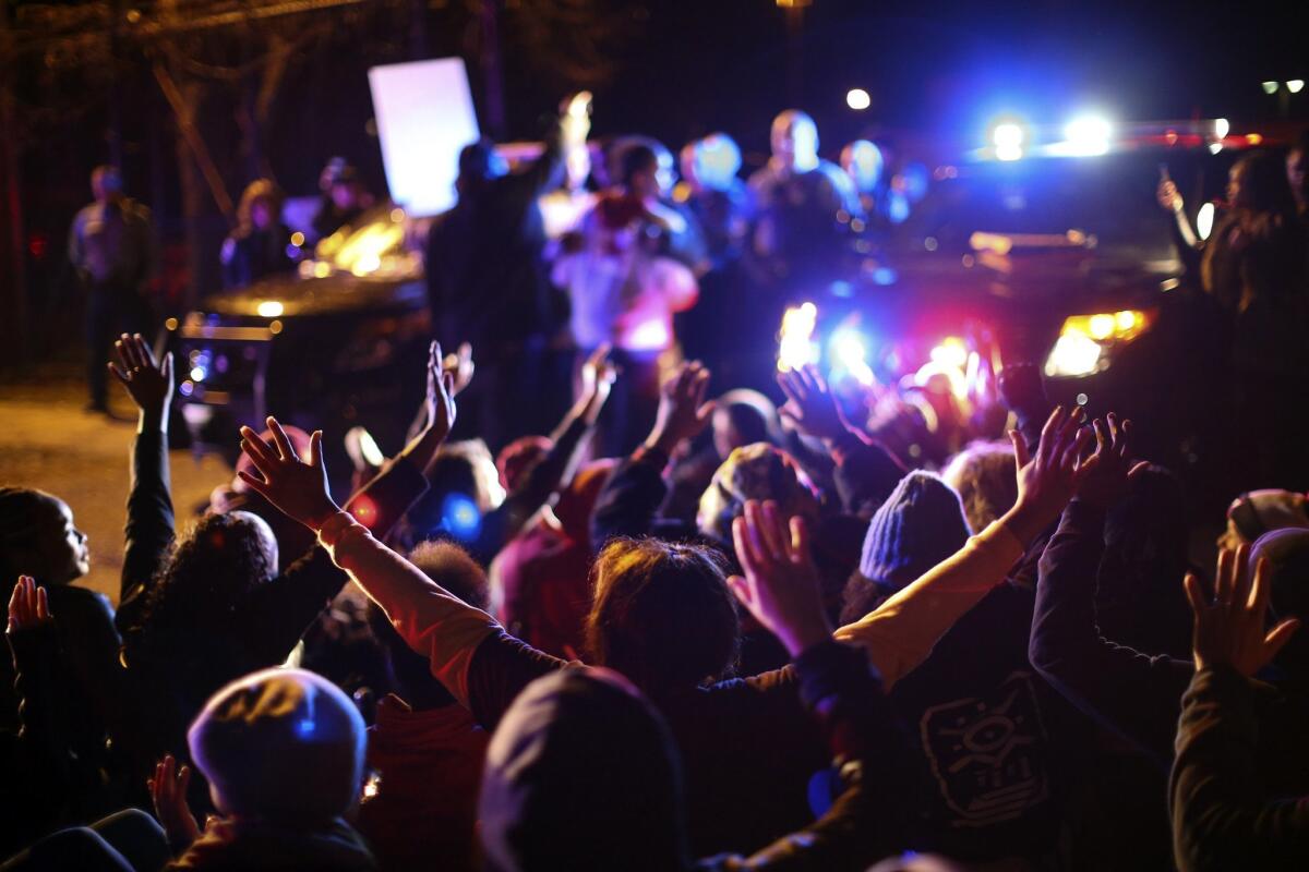 Some demonstrators sat down in the street as others chanted at Minneapolis police officers at the side entrance to the 4th Precinct station after a man was shot Sunday by Minneapolis police.
