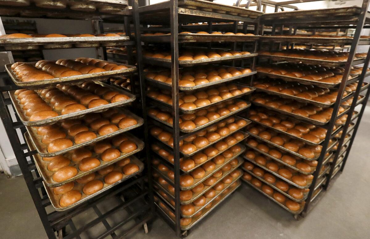 Racks of freshly baked buns at Bread Artisan Bakery in Santa Ana.