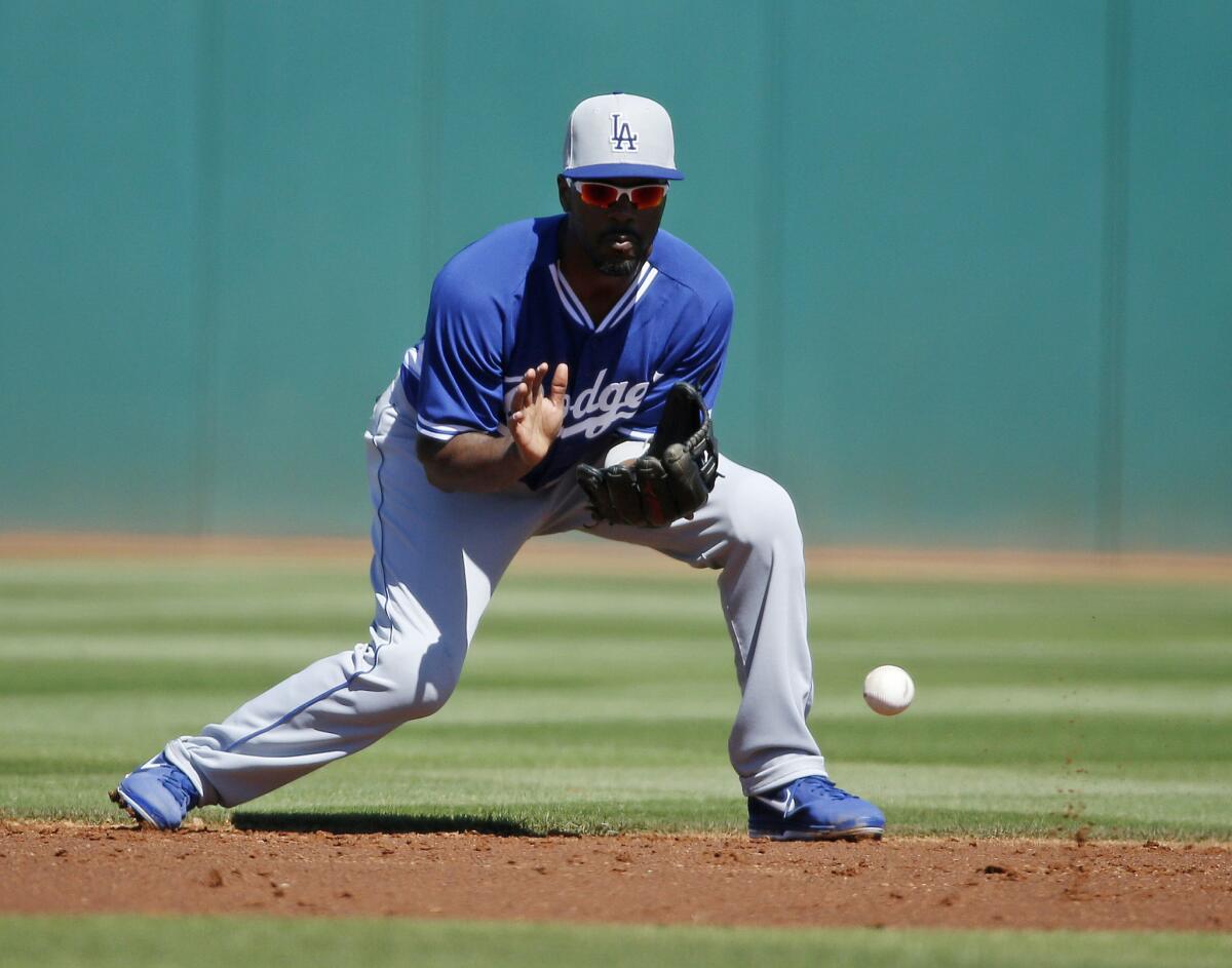 Dodgers shortstop Jimmy Rollins fields a ball before throwing a runner out at first base during a spring training game against the Cleveland Indians on March 7.