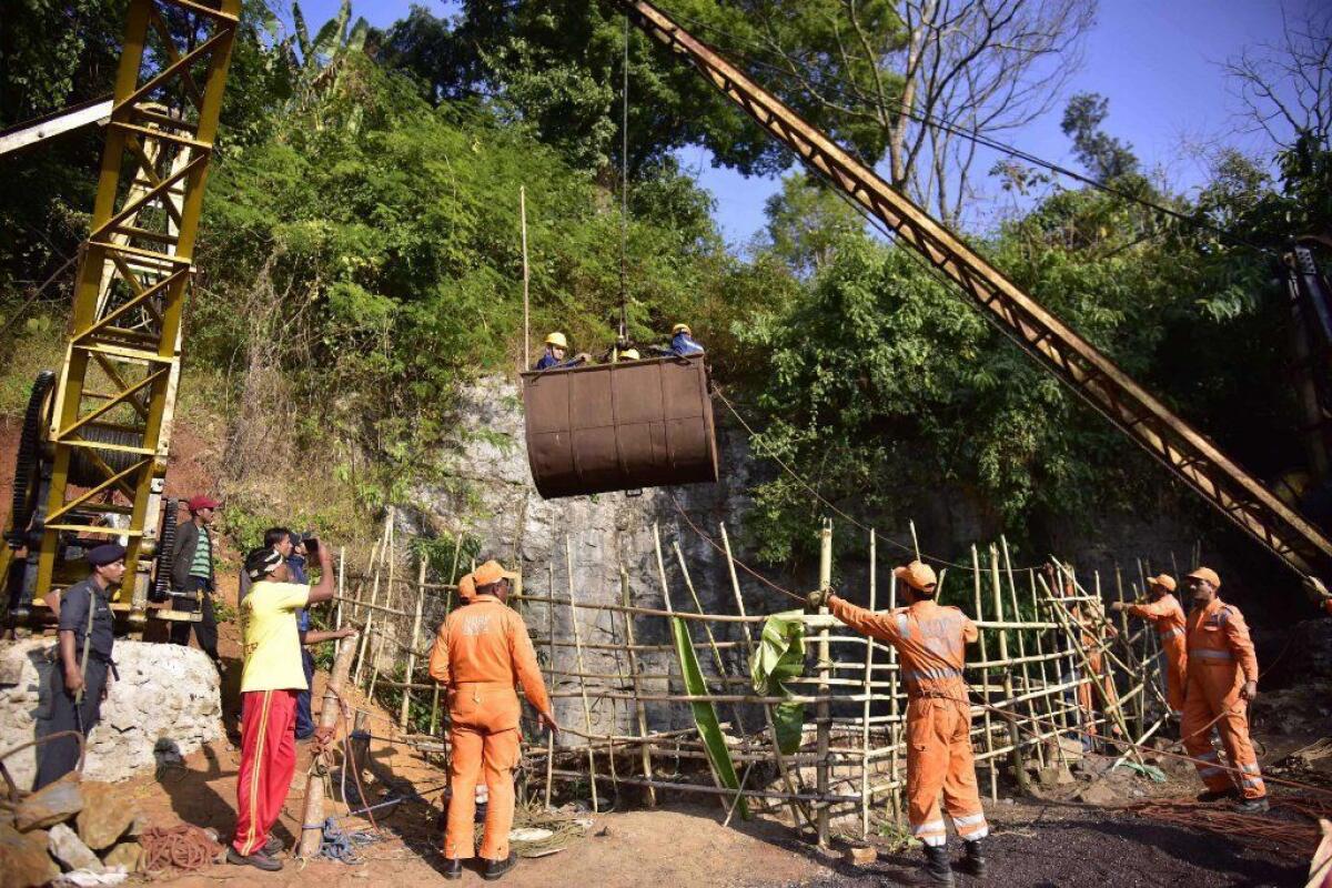 Indian National Disaster Response Force personnel gather around a crane during rescue operations to help 15 men trapped by flooding in an illegal coal mine in Ksan village in northeastern India.