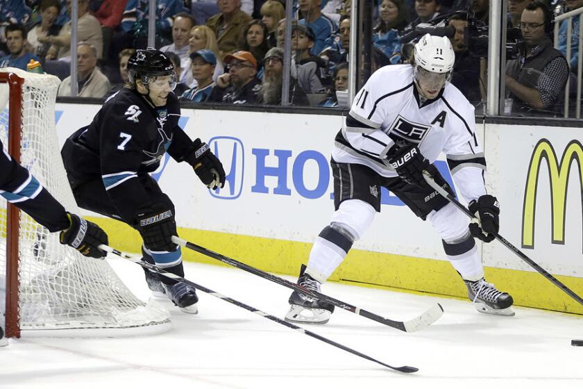 Kings center Anze Kopitar (11) maneuvers behind the net as Sharks defenseman Brad Stuart (7) pursues the play during the first period of Game 1 on Thursday, in San Jose.