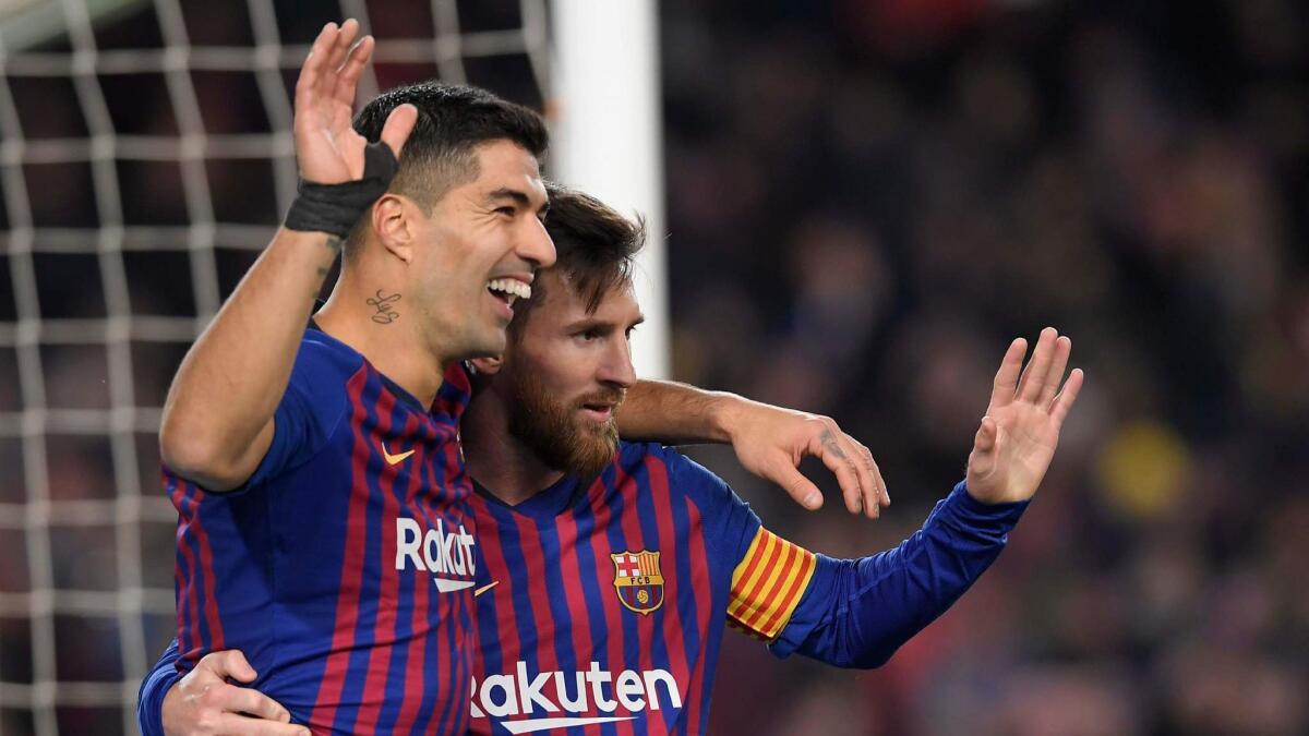 Barcelona's Luis Suarez, left, celebrates with Lionel Messi after scoring during a Spanish Copa del Rey quarterfinal second-leg match against Sevilla at Camp Nou on Jan. 30.