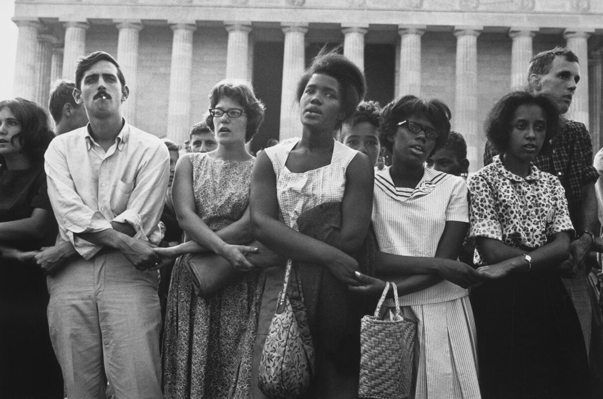 Demonstrators link hands before the Lincoln Memorial, in a photo from the book "This Is the Day: The March on Washington."