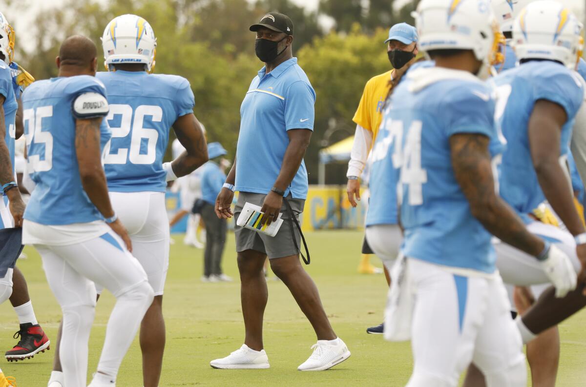 Chargers coach Anthony Lynn works with players at the team's training complex in Costa Mesa on Aug. 17.