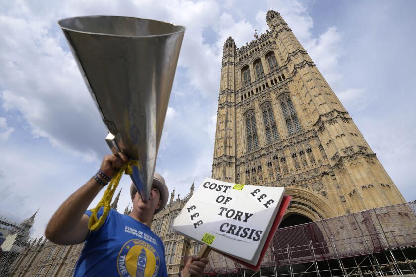 A protestor shouts outside parliament during elections for a new executive of the Conservative 1922 committee, which helps set party rules in London, Monday, July 11, 2022. The 1922 committee will immediately meet once the vote has taken place to decide on the rules of the road for the Conservative leadership contest. (AP Photo/Frank Augstein)