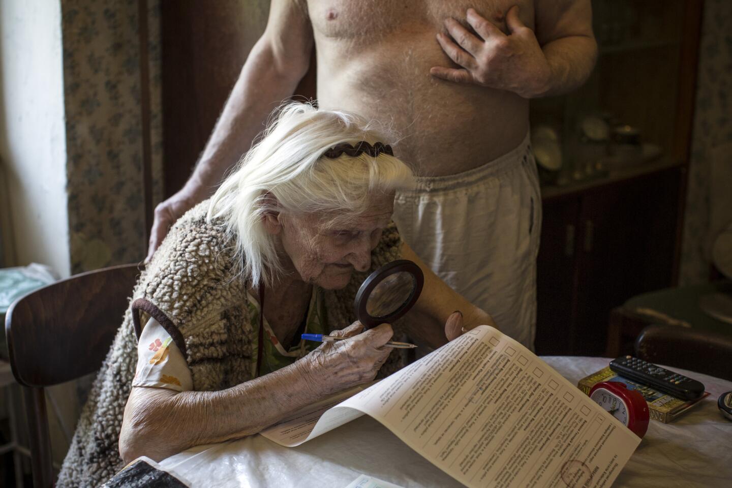 Katerina Lucento, 93, a retired factory worker, casts her vote from her home as election staff collect ballots from people too infirm to visit a polling station on May 25 in Kiev, Ukraine.