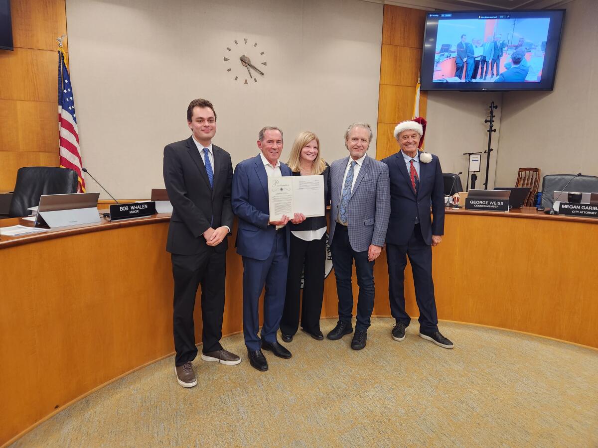 Bob Whalen, second from left, is presented with a resolution in recognition of his fifth term as mayor of Laguna Beach.