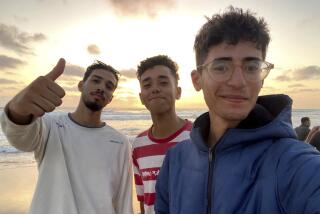 In this undated photo provided by Helmi Hirez, Mohamed (Medo) Halimy, left, and twin brothers Mohammed Hirez, center, and Helmi Hirez, right, stand on a beach in Gaza. (Helmi Hirez via AP).